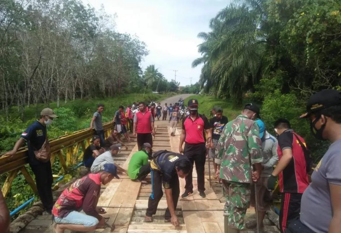 Personil Kepolisian Sektor Giri Mulya Bantu Warga Perbaiki Jembatan Penghubung Desa